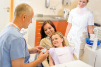 Kind besucht Zahnarztpraxis mit Mutter